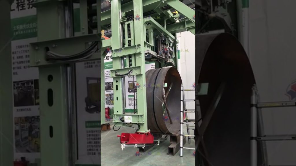 A steel coil strapping machine for large size coils, with automatic functionality. A steel coil strapping machine for large size coils, with automatic functionality.